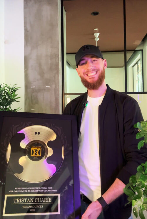 Tristan Charié avec le trophée Two Comma Club de ClickFunnels, récompense pour un tunnel de vente ayant généré plus d'un million de chiffre d'affaires